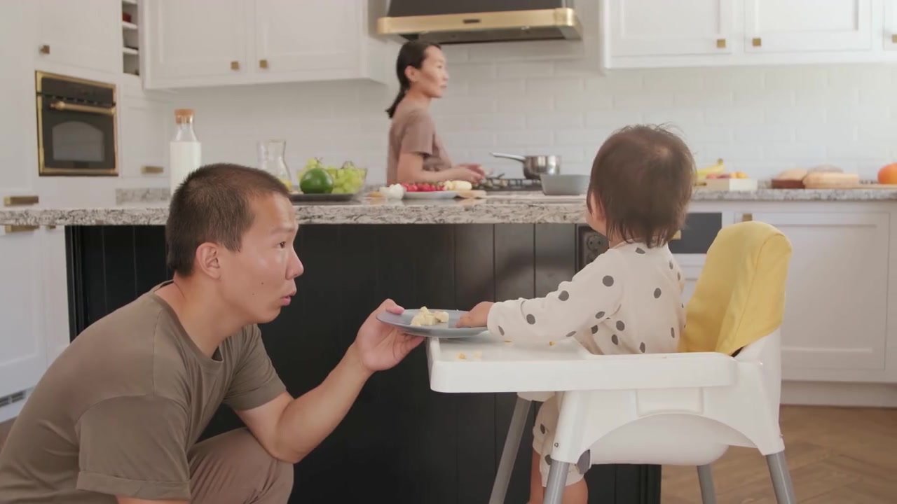 爸爸陪宝宝吃饭，妈妈在身旁